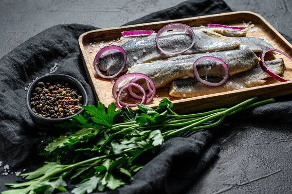 Filete de arenque marinado con pimienta, hierbas y cebolla roja. Fondo negro. Vista superior — Foto de Stock