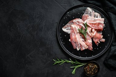 Siyah tabakta domuz pastırması. Çiftlik organik eti. Siyah arka plan. Üst Manzara. Metin için boşluk