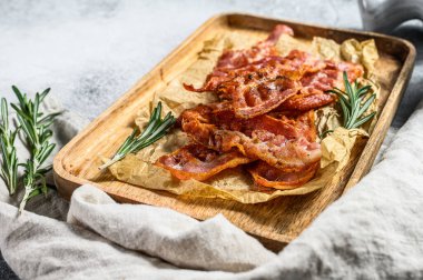 Kraft kağıdında ahşap tepside kızarmış pastırma. Çiftlik organik domuz eti. Gri arka plan. Üst görünüm.