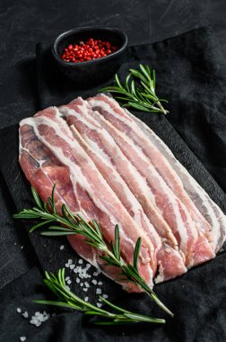 Kaya kesme tahtasındaki pastırma dilimleri. Domuz eti. Siyah arka plan. Üst görünüm