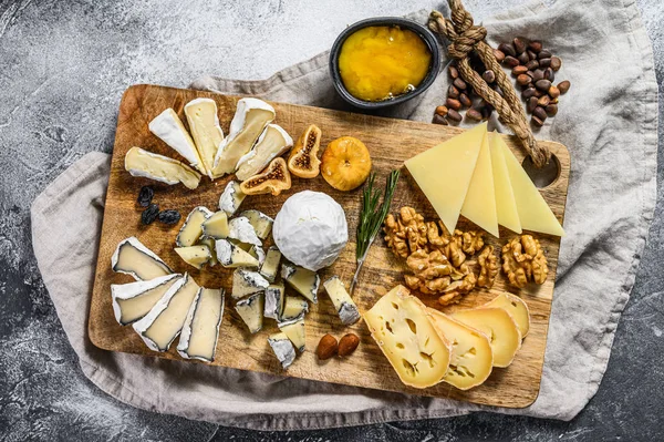 Käseplatte mit französischem Biokäse, Feigen, Nüssen auf grauem Hintergrund. Ansicht von oben. Leckere Käsevorspeise — Stockfoto