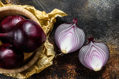 Tahta bir kasede kırmızı organik soğan. Çiftlik sebzeleri. Karanlık arka plan. Üst görünüm.