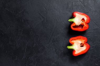 Kırmızı dolmalık biber, iki yarım. Siyah arka plan. Üst Manzara. Metin için boşluk
