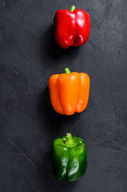 Yeşil, turuncu ve kırmızı dolma biber. Siyah arka plan. Üst Manzara. Metin için boşluk.