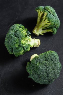 Siyah arka planda çiğ yeşil brokoli. Üst görünüm