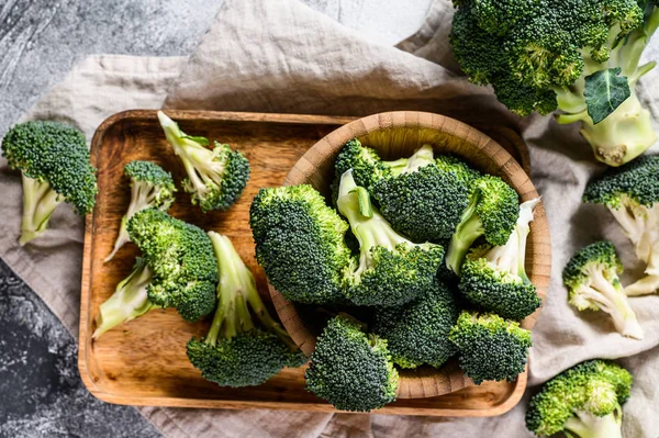 Raw broccoli in a wooden bowl. Gray background. Top view — Stock Photo, Image