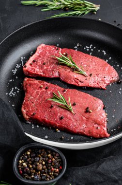 Kızartma tavasında çiğ fileto biftek. Et eti. Siyah arka plan. Üst görünüm