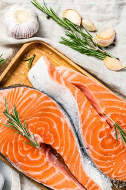 Baharatlı ahşap tepside çiğ somon bifteği. Sağlıklı deniz ürünleri. Gri arka plan. Üst görünüm