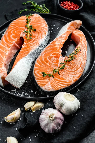 Čerstvý lososí steak na talíři s kořením. Atlantická ryba. Černé pozadí. Horní pohled — Stock fotografie