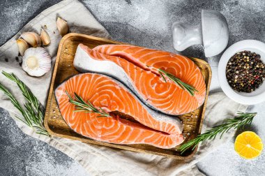 Tahta tepside baharatlı taze alabalık bifteği. Sağlıklı deniz ürünleri. Gri arka plan. Üst görünüm