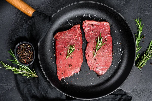 Nyers hátszín steak serpenyőben. Marhahús. Fekete háttér. Felülnézet — Stock Fotó
