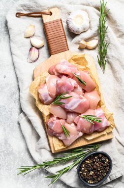 Baharatlı küp kesilmiş çiğ tavuk filetosu. Gri arka plan. Üst görünüm