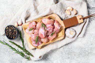 Baharatlı küp kesilmiş çiğ tavuk filetosu. Gri arka plan. Üst görünüm