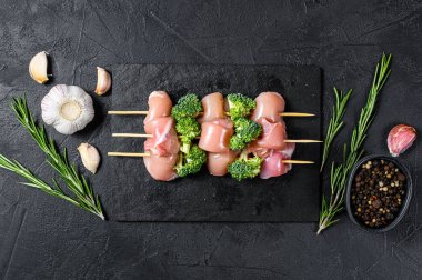 Şiş üzerinde taze çiğ tavuk parçaları. Siyah arka plan. Üst görünüm