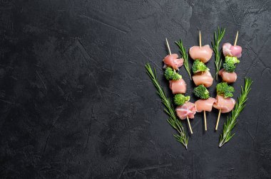 Çiğ tavuk şiş kebap, brokoli, barbekü. Siyah arka plan. Üst Manzara. Metin için boşluk