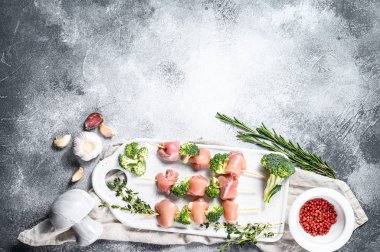 Çiğ tavuk kebabı ve brokoli. Gri arka plan. Üst Manzara. Metin için boşluk