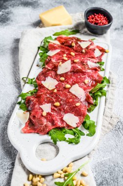 Çiğ mermerden yapılmış Carpaccio. Gri arka plan. Üst görünüm