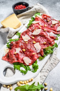 Parmesan peynirli siyah angus bifteği carpaccio. Gri arka plan. Üst görünüm