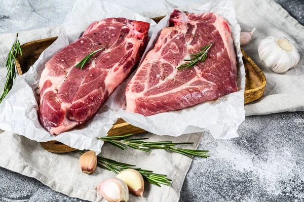 Raw pork steak on the bone. Marbled farm meat. Gray background. Top view — Stock Photo, Image