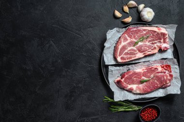 Çiğ domuz eti. Kağıt üzerinde mermer et. Siyah arka plan. Üst Manzara. Metin için boşluk