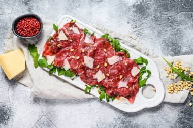Çiğ mermerden yapılmış Carpaccio. Gri arka plan. Üst görünüm