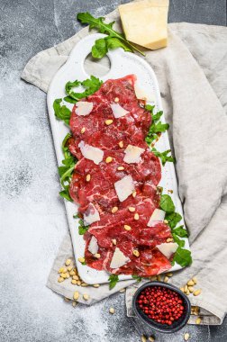 Parmesan peynirli siyah angus bifteği carpaccio. Gri arka plan. Üst görünüm