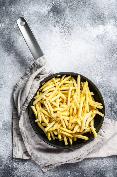 Frozen French fries in a frying pan. Gray background. Top view. Space for text — Stock Photo, Image
