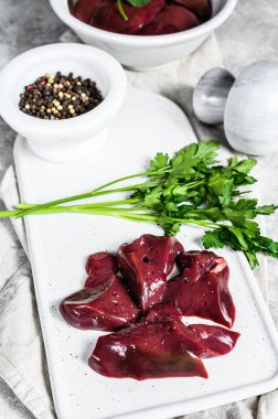 Tabakta çiğ hindi ciğeri. Gri arka plan. Üst görünüm