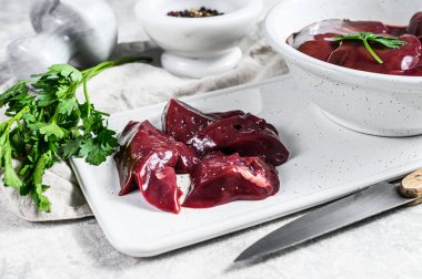 Tabakta çiğ hindi ciğeri. Gri arka plan. Üst görünüm