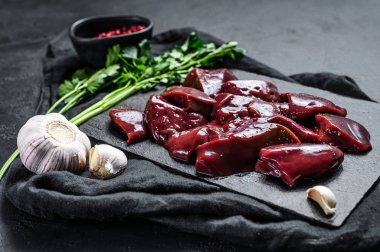 Taş tahtada çiğ hindi ciğeri. Siyah arka plan. Üst görünüm