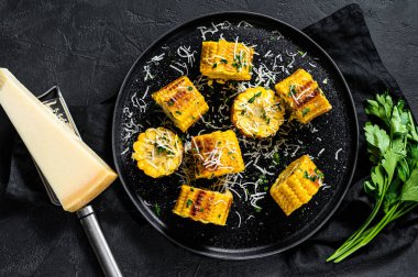 Parmesan ve maydanozla kızartılmış mısır. Organik çiftlik sebzeleri. Siyah arka plan. Üst görünüm