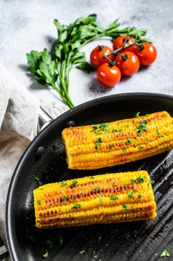 Kızartma tavasında organik ızgara mısır. Organik çiftlik sebzeleri. Gri arka plan. Üst görünüm