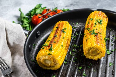 Kızartma tavasında organik ızgara mısır. Organik çiftlik sebzeleri. Gri arka plan. Üst görünüm