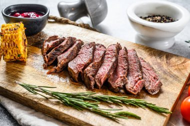 Tahta doğrama tahtasında dilimlenmiş fileminyon biftek. Sığır filetosu. Gri arka plan. Üst görünüm