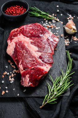 Doğrama tahtasında çiğ biftek. Organik çiftlik eti. Siyah arkaplan