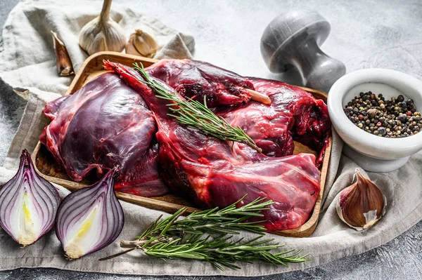 Hare meat. Raw fresh wild hare on a wooden table with vegetables and spices. Top view. Organic meat — Stock Photo, Image