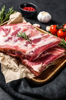 Biberiyeli taze domuz pirzolası ve ahşap bir kasede sarımsak. Siyah arka plan. Üst görünüm