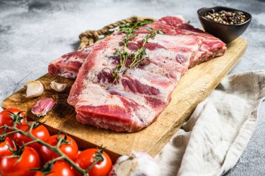 Çiftlik organik eti. Biberiye, biber ve sarımsaklı çiğ domuz pirzolası. Gri arka plan. Üst görünüm