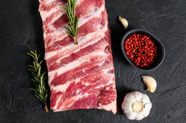 Biberiye ve sarımsaklı taze domuz pirzolası. Siyah arka plan. Üst görünüm