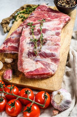 Biberiye, biber ve sarımsaklı taze çiğ domuz pirzolası. Çiftlik organik eti. Gri arka plan. Üst görünüm