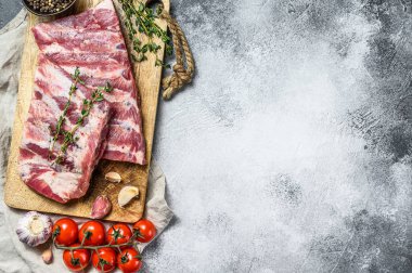 Biberiye, biber ve sarımsaklı taze çiğ domuz pirzolası. Çiftlik organik eti. Gri arka plan. Üst Manzara. Metin için boşluk