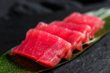 Taş tahtada saşimi ton balığı. Siyah arka plan. Üst Manzara. Kapat.