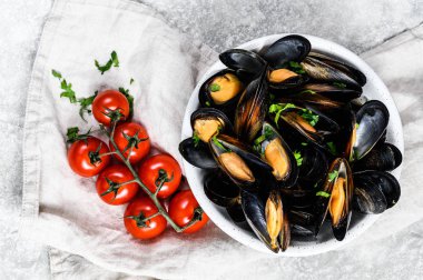 Otlu midyeler ve kabın içinde sos. Gri arka plan. Üst görünüm