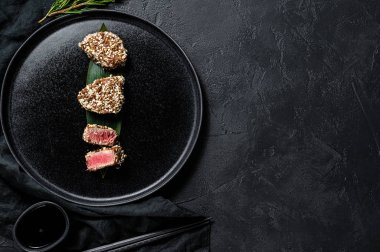 Tabakta ızgara ton balığı bifteği. Siyah arka plan. Üst Manzara. Metin için boşluk