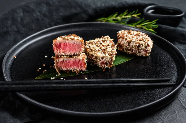 Gegrilltes Thunfischsteak in Sesam. schwarzer Hintergrund. Ansicht von oben — Stockfoto