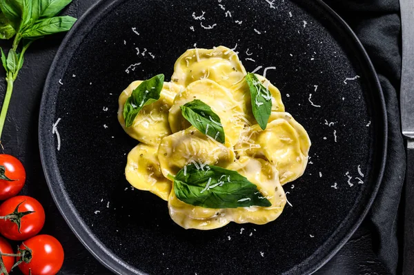 Prato de ravioli com parmesão e manjericão. Fundo preto. Vista superior — Fotografia de Stock