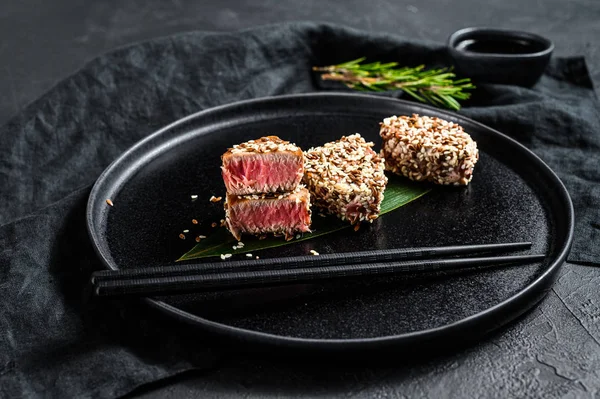 Gegrilltes Thunfischsteak in Sesam. schwarzer Hintergrund. Ansicht von oben — Stockfoto