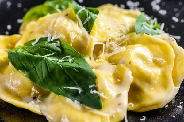 Italské ravioli těstoviny se sýrem a bazalkou. Černé pozadí. Horní pohled — Stock fotografie