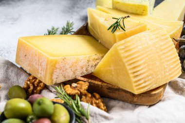 Fındık zeytinli ve üzümlü farklı peynir parçaları. Çeşit çeşit lezzetli atıştırmalıklar. Gri arka plan. Üst görünüm