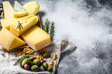 Üzüm, kraker, zeytin ve fındık ile servis edilen peynir tabağı. Çeşit çeşit lezzetli atıştırmalıklar. Gri arka plan. Üst Manzara. Metin için boşluk